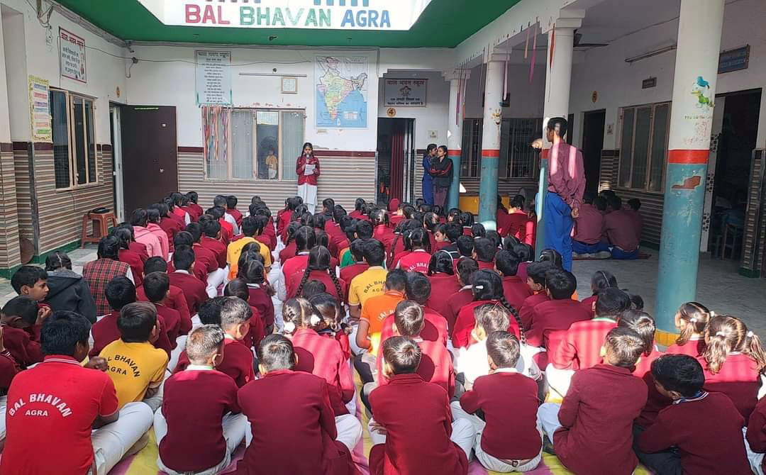 A school child in an Earth costume holding drawing of Save Trees